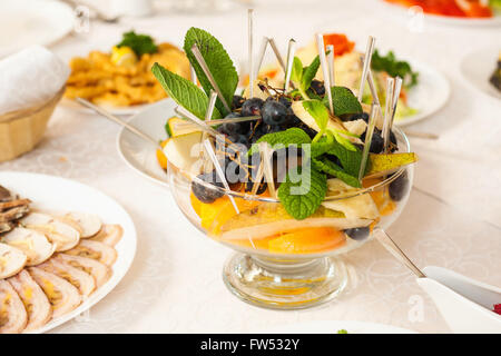 Nahaufnahme der Schale mit frischem Obst. In Scheiben geschnitten, Birne, Orange und Beeren der blauen Traube Stockfoto