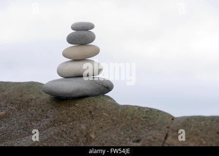 Fünf glatten Steinen Gleichgewicht auf einem Felsen an einem Strand West Coast, Südinsel, Neuseeland Stockfoto