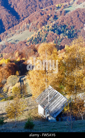 Landstraße im Herbst Berg und bunte Bäume und Holz Scheune am Hang. Stockfoto