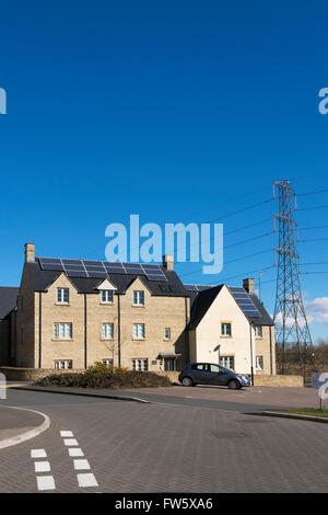 Sonnenkollektoren auf dem Dach der Häuser in einer neuen Wohnsiedlung am Stadtrand von Cirencester, Gloucestershire, UK Stockfoto