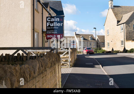 Immobilienmakler-Board in einer neuen Wohnsiedlung am Stadtrand von Cirencester, Gloucestershire, UK Stockfoto