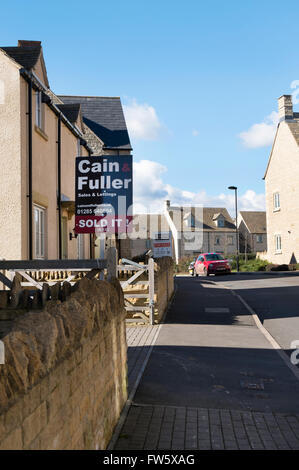 Immobilienmakler-Board in einer neuen Wohnsiedlung am Stadtrand von Cirencester, Gloucestershire, UK Stockfoto