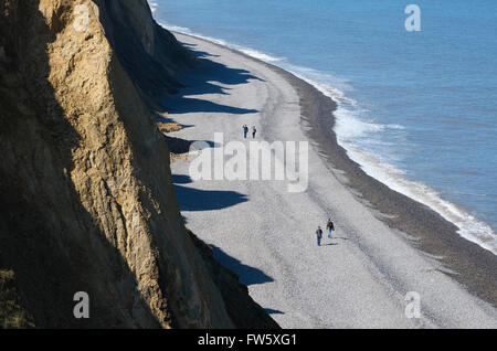 Menschen zu Fuß auf Kiesstrand in sheringham Stockfoto