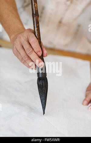 Chinesische Kalligraphie Szene, Alter Mann mit einem Pinsel Stockfoto