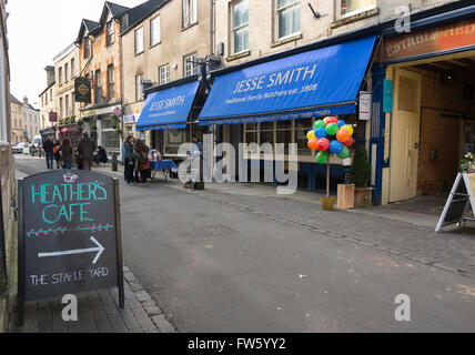 Burger und Würstchen gekocht wird außen Jesse Smith Fleischer in Black Jack Street, Cirencester, Gloucestershire, Großbritannien Stockfoto