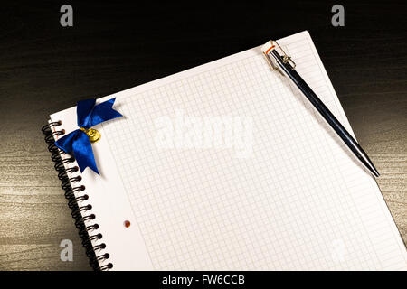 Notebook mit leeren Seiten öffnen und Bleistift auf schwarzem Hintergrund aus Holz Stockfoto