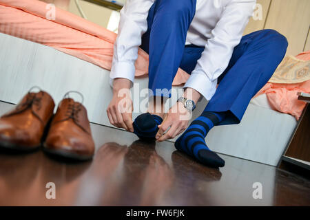 Mann, der seine Socken mit Schuhen vor ihm Stockfoto