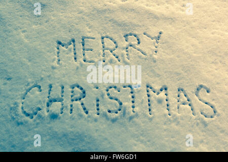 Geschriebene Worte Frohe Weihnachten auf ein Schneefeld, Neujahr-Konzept. Stockfoto