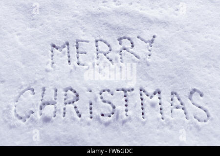 Geschriebene Worte Frohe Weihnachten auf ein Schneefeld, Neujahr-Konzept. Stockfoto