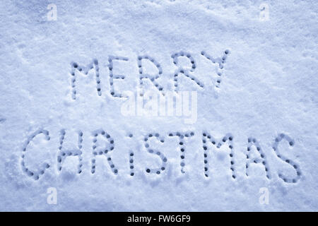 Geschriebene Worte Frohe Weihnachten auf ein Schneefeld, Neujahr-Konzept. Stockfoto