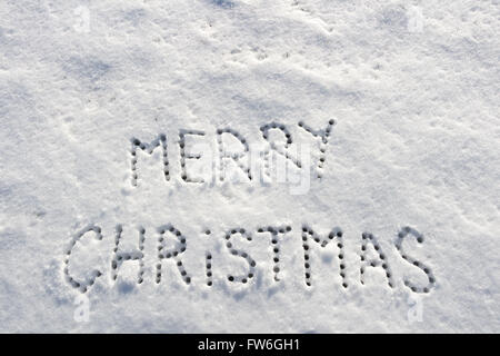 Geschriebene Worte Frohe Weihnachten auf ein Schneefeld, Neujahr-Konzept. Stockfoto