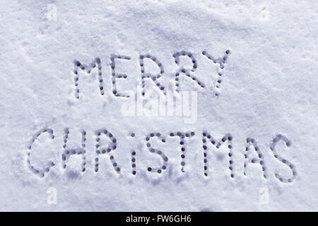 Geschriebene Worte Frohe Weihnachten auf ein Schneefeld, Neujahr-Konzept. Stockfoto