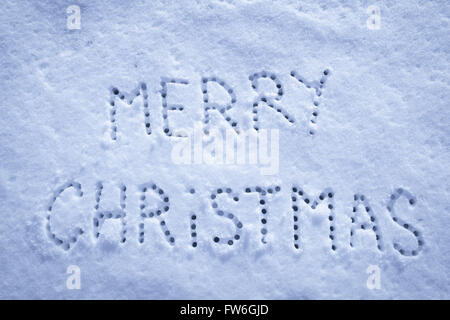 Geschriebene Worte Frohe Weihnachten auf ein Schneefeld, Neujahr-Konzept. Stockfoto