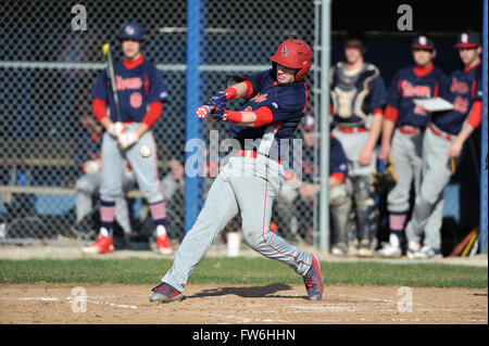 Linkshänder Teig erfolgreiche Kontakt während eines High School Baseball Spiel als seine Mannschaftskameraden vom Einbaum über beobachten. USA. Stockfoto