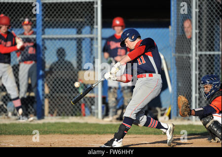 Während sein Kopf nach unten halten durch Kontakt, ein High School hitter ist mit einem scharfen Single zum outfield belohnt. USA. Stockfoto