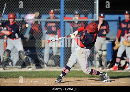 High School hitter, guten Kontakt, während unter den wachsamen Augen seiner Mannschaftskameraden aus dem Dugout. USA. Stockfoto