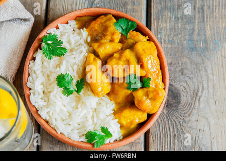 Hühnchen-Curry mit Reis auf einer Holzoberfläche Stockfoto