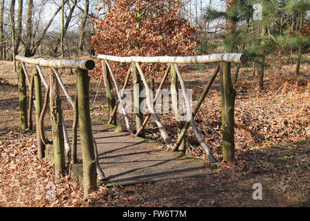 Eine hölzerne Brücke über einen kleinen Wald Bach. Stockfoto