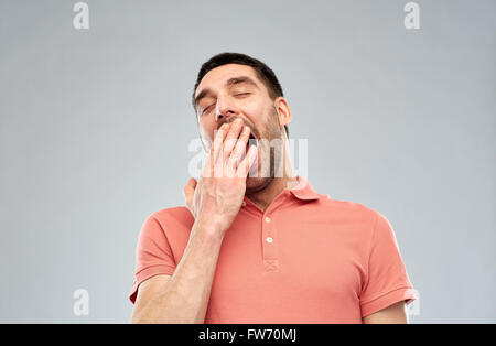 gähnende Menschen über grauen Hintergrund Stockfoto