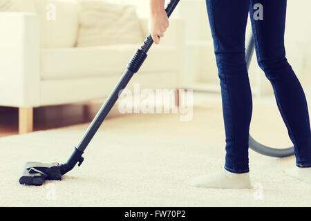 Nahaufnahme von Frau Beine mit Staubsauger zu Hause Stockfoto