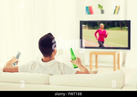 Mann Sport im Fernsehen beobachten und trinken Bier zu Hause Stockfoto