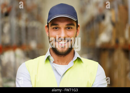 glücklicher Mensch in reflektierende Warnweste im Lager Stockfoto