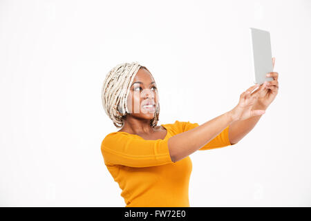 Attraktive fröhliche junge afroamerikanische Frau weißen Hintergrund Selfie mit Tablet-Übernahme Stockfoto