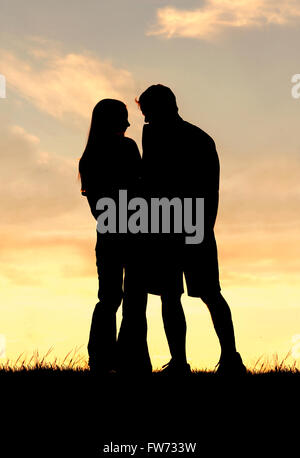 Ein liebendes Paar von Mann und Frau sind Lachen und Hand in Hand außerhalb während wieder den Sonnenuntergang in den Himmel abhebt. Stockfoto