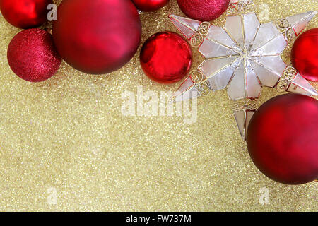 Rote Lampe Weihnachtsschmuck und ein Stern geformt Tree Topper Grenze am Seitenanfang ein Hintergrundstoff Goldglitter mit Textfreiraum. Stockfoto