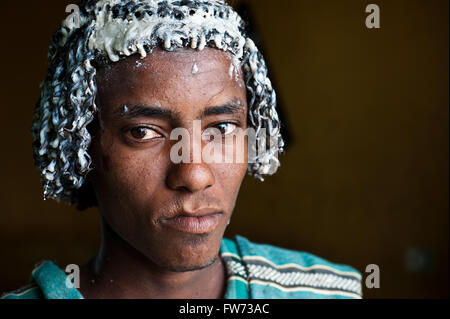 Junger Mann aus der Afar-Stamm. Der Afar-Tradition entsprechend hat er Butter auf seine Haare zu beschützen... Stockfoto