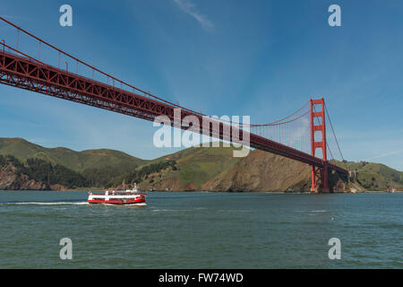 Die Golden Gate Bridge mit Ausflugsschiff vorbei darunter, in der Nähe von San Francisco, Kalifornien, USA Stockfoto