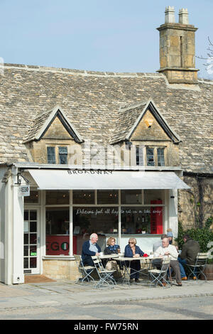 Touristen, die mit Tee am Nachmittag vor einem Café in Broadway, Cotswolds Worcestershire England Stockfoto