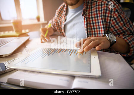 Geschäftsdokumente auf Bürotisch mit Smartphone und digitale Tablet / Graph Business-Diagramm und Mann arbeitet Stockfoto