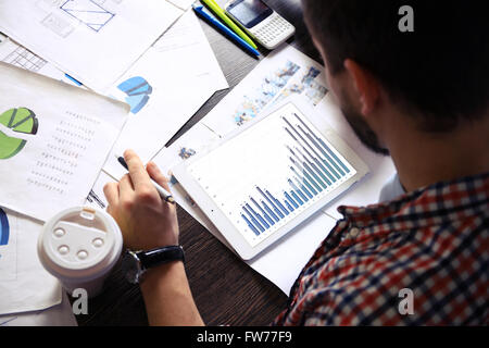 Geschäftsdokumente auf Bürotisch mit Smartphone und digitale Tablet / Graph Business-Diagramm und Mann arbeitet Stockfoto