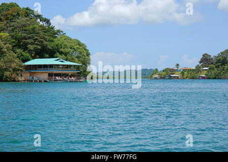 Loma Partida im Archipel von Bocas del Toro mit einem Restaurant über das Wasser auf der linken Seite, Panama Kanal Stockfoto