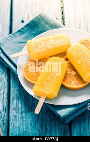 hausgemachte leckere Eis am Stiel mit frischen orange, lebendige Farben blau und orange Stockfoto