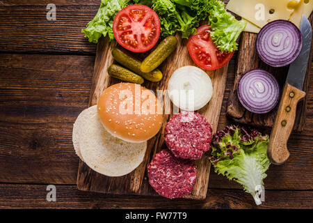 Hausgemachte Burger Zutaten auf rustikalen Holztisch Stockfoto