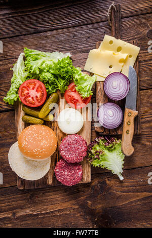 Hausgemachte Burger Zutaten auf rustikalen Holztisch Stockfoto