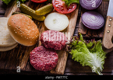 Hausgemachte Burger Zutaten auf rustikalen Holztisch Stockfoto