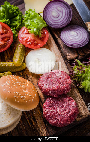 Hausgemachte Burger Zutaten auf rustikalen Holztisch Stockfoto