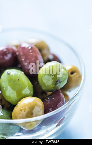 Frische ganze Oliven in Schüssel geben, mit Öl und Gewürzen. Spanische Tapas-Konzept. Stockfoto