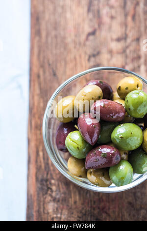 Frische ganze Oliven in Schüssel geben, mit Öl und Gewürzen. Spanische Tapas-Konzept. Stockfoto