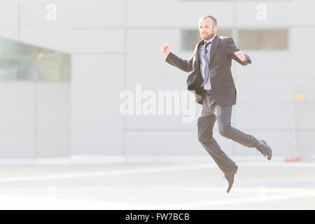 Dynamischen Geschäftsmann springen im Freien in der Stadt Stockfoto