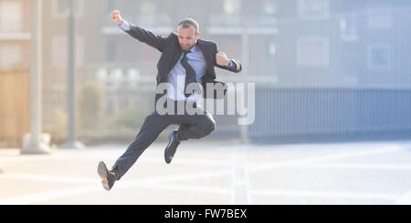 Dynamischen Geschäftsmann springen im Freien in der Stadt Stockfoto