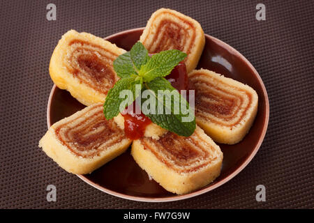 Bolo de Rolo (Swiss Roll, Roll Kuchen) brasilianischen Dessert auf braune Teller. Selektiven Fokus Stockfoto