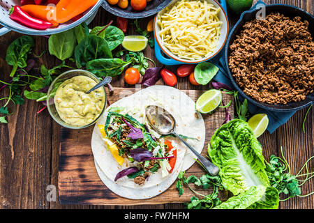 Traditionelle mexikanische Fajitas oder Tortillas machen auf Holztisch, einfache Suppen. Draufsicht. Stockfoto