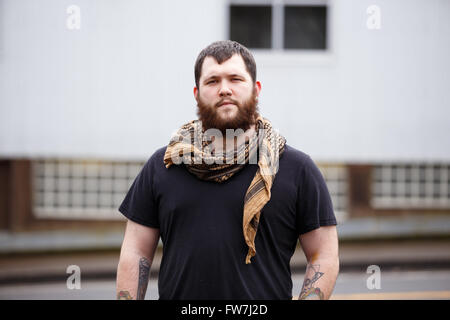 EUGENE, OR - 20. März 2016: Städtebauliches Portrait eines bärtigen Hipster-Menschen mit Tattoos. Stockfoto