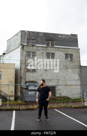 EUGENE, OR - 20. März 2016: Städtebauliches Portrait eines bärtigen Hipster-Menschen mit Tattoos. Stockfoto