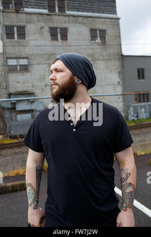 EUGENE, OR - 20. März 2016: Städtebauliches Portrait eines bärtigen Hipster-Menschen mit Tattoos. Stockfoto