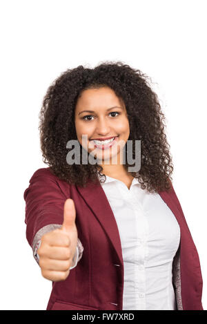 Schneiden Sie Bild einer jungen lächelnde Frau mit braunen lockigen Haaren (Afro), die ihr Daumen zeigt. Fokus liegt auf dem Gesicht, Hand ist o Stockfoto